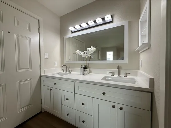a bathroom with a double vanity sink and a mirror