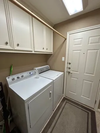 a utility room with cabinets washer and dryer