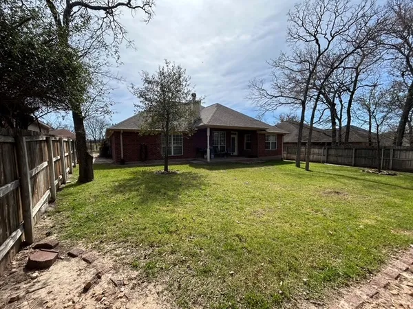 a view of a house with a yard porch and tree