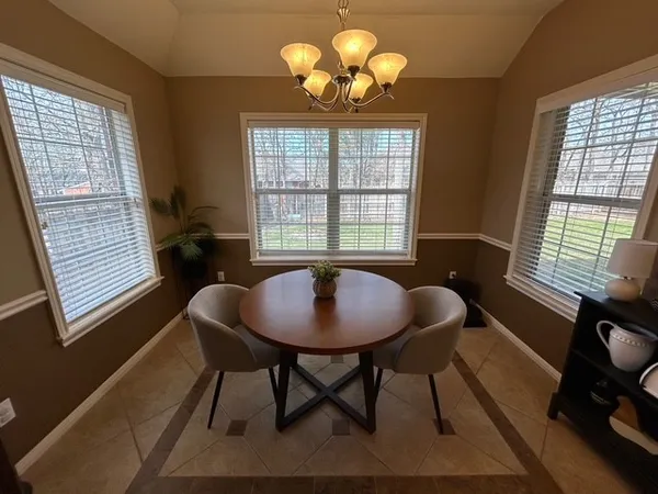 a view of a dining room with furniture a chandelier and wooden floor