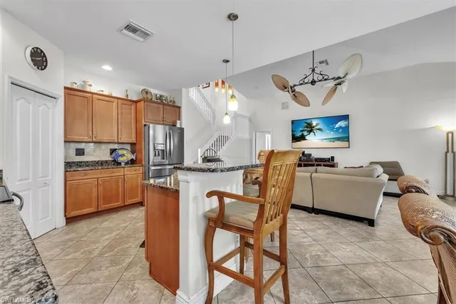 a kitchen with kitchen island a stove a table and chairs in it