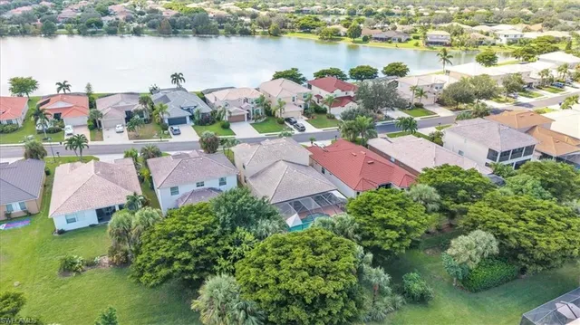 an aerial view of residential houses with outdoor space and lake view