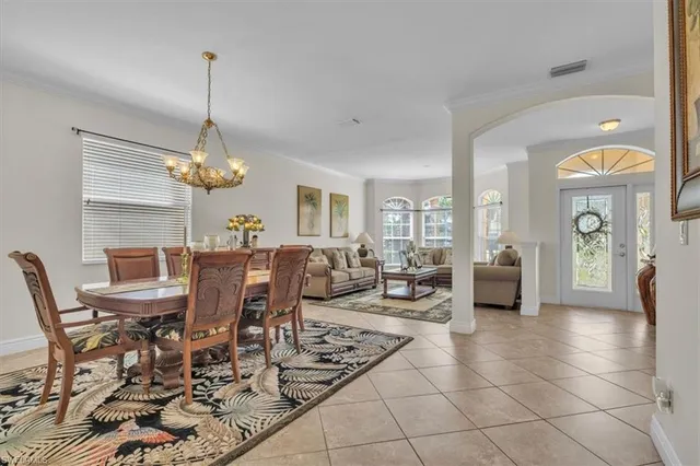 a view of a dining room and livingroom with furniture wooden floor a chandelier