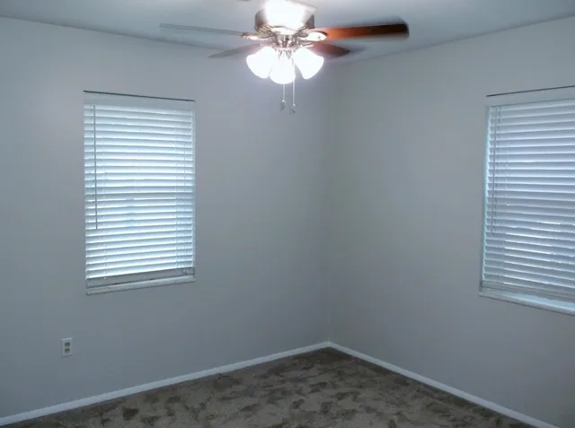 a room with a window and a chandelier fan
