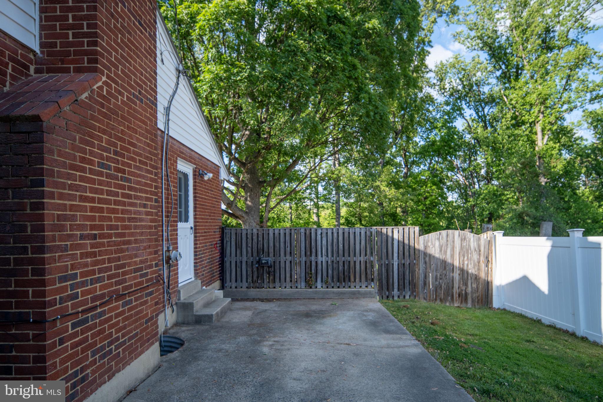 6714 Ruskin Street Springfield, VA 22150 - Photo 48 of 63 a view of a backyard with wooden fence and large trees