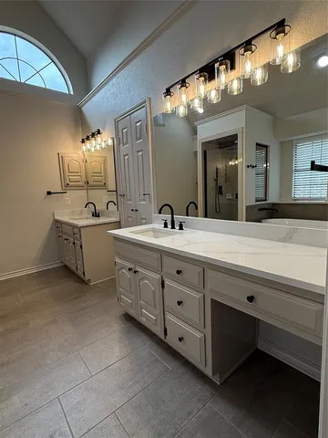 a bathroom with a double vanity sink and a mirror