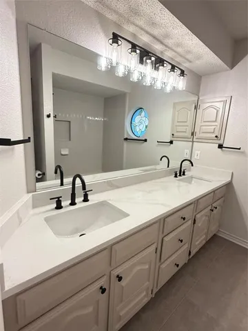 a bathroom with a double vanity sink and a mirror
