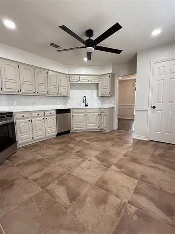 a large kitchen with cabinets and wooden floor