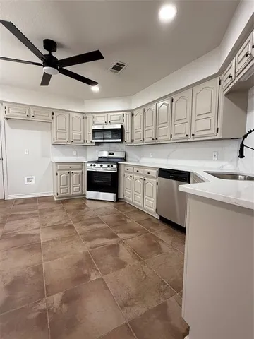 a kitchen with a sink a stove and cabinets