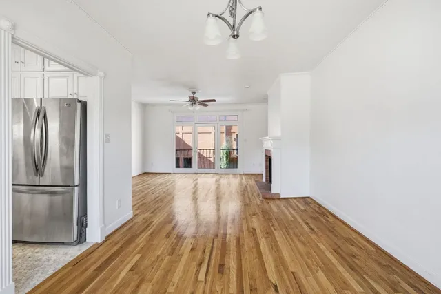 a kitchen with stainless steel appliances granite countertop a refrigerator a sink and white cabinets