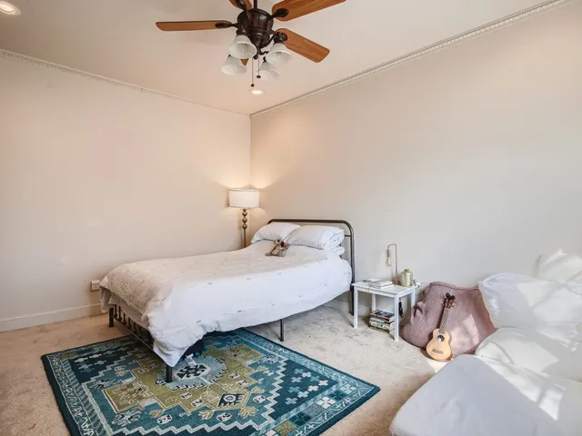 a spacious bedroom with a bed a couch and chandelier