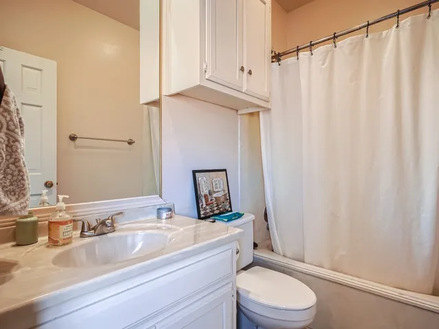 a bathroom with a granite countertop sink toilet and a mirror