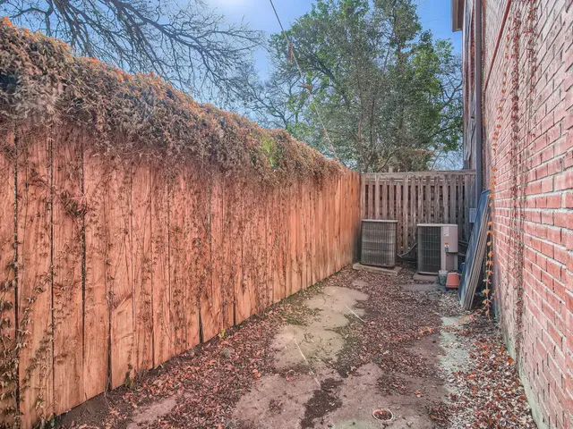 a view of backyard with wooden fence and trees
