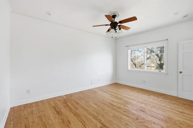 a view of an empty room with wooden floor