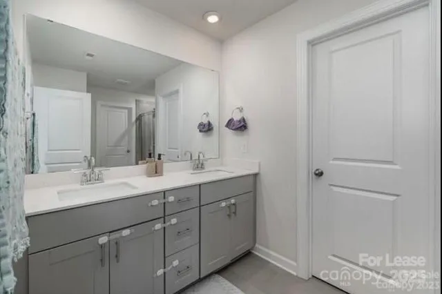 a bathroom with a double vanity sink and mirror