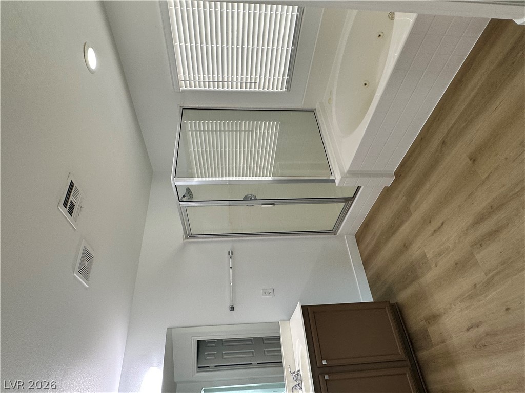 9639 West Post Road Las Vegas, NV 89148 - Photo 25 of 30 A glass-enclosed shower alongside a deep soaking tub provides a serene bath experience.