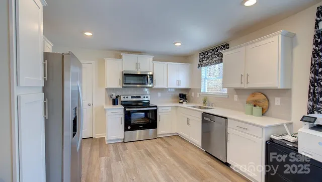a kitchen with stainless steel appliances a refrigerator sink and microwave