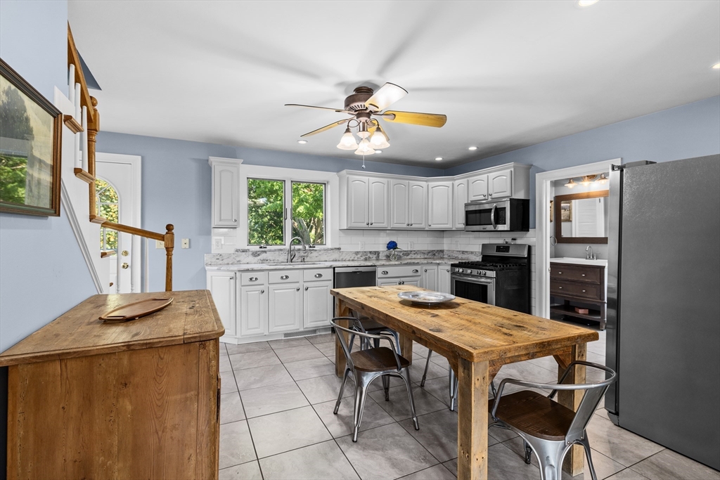 11 Saucier Street Acushnet, MA 02743 - Photo 4 of 35 a kitchen with stainless steel appliances kitchen island granite countertop a table chairs and a refrigerator