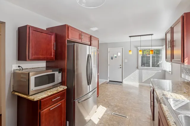 a kitchen with stainless steel appliances a refrigerator and a stove top oven