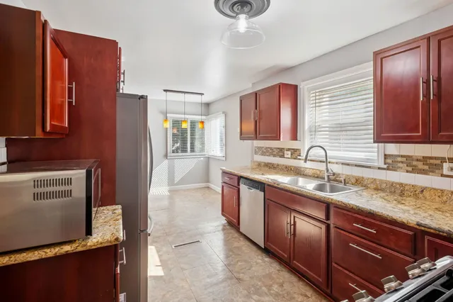 a kitchen with stainless steel appliances granite countertop a sink stove and refrigerator