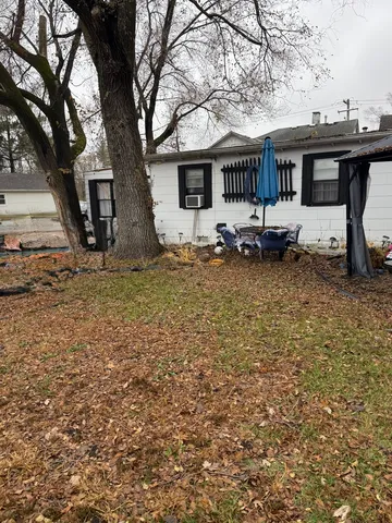 a backyard of a house with table and chairs