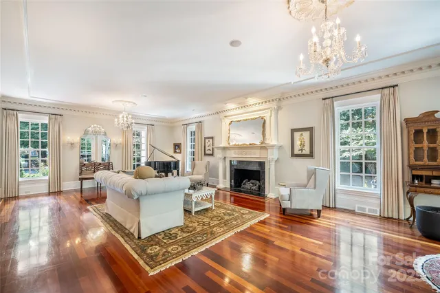 a living room with furniture a fireplace and a chandelier