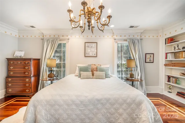 a spacious bedroom with a bed and a chandelier