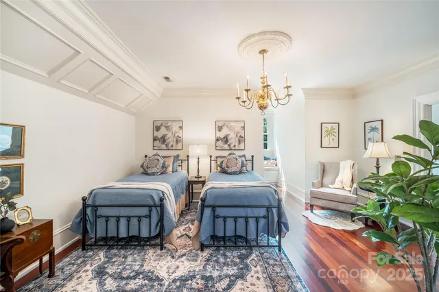 a bedroom with two beds and a chandelier