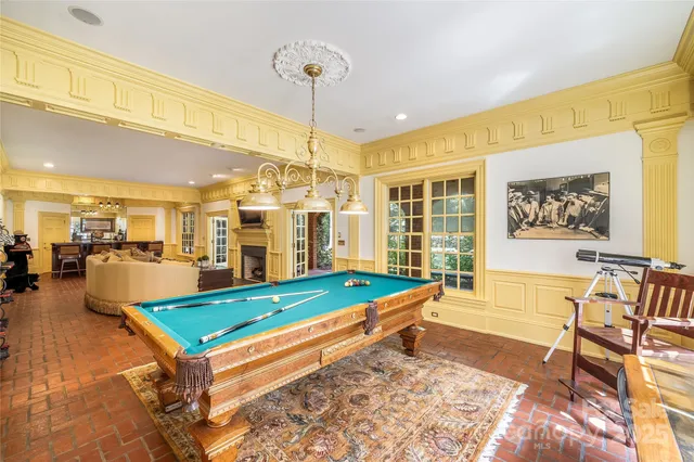 a room with pool table and windows