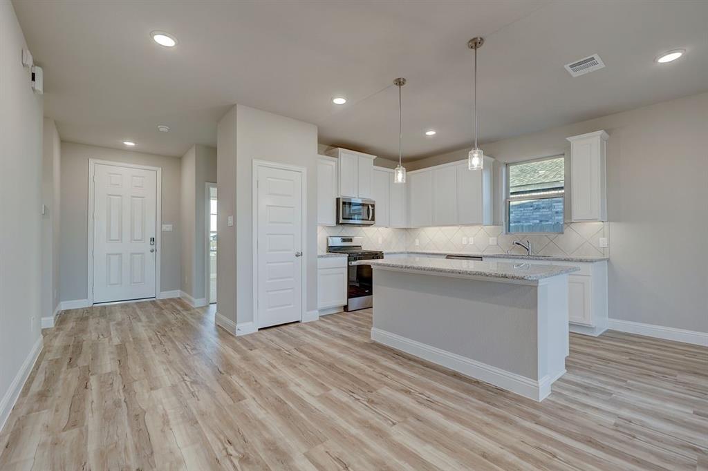 125 Toftrees Drive Cleburne, TX 76031 - Photo 4 of 22 a kitchen with granite countertop a white stove top oven and cabinets