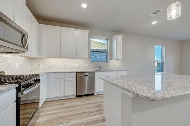 a bathroom with a granite countertop double vanity sink and mirror