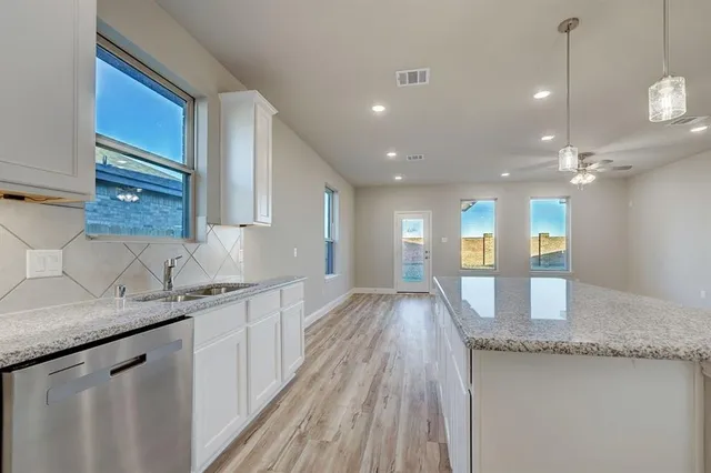 a open kitchen with a sink a refrigerator and wooden floor
