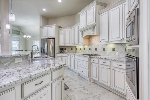 a kitchen with stainless steel appliances granite countertop a sink stove and cabinets