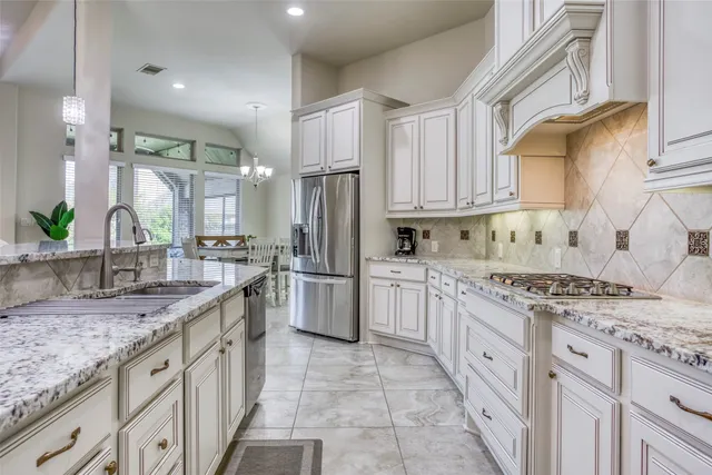 a kitchen with stainless steel appliances granite countertop a sink stove and refrigerator