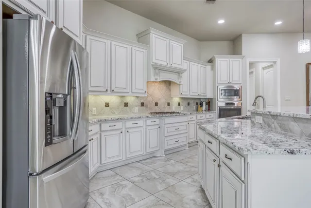 a kitchen with stainless steel appliances granite countertop a refrigerator sink and cabinets