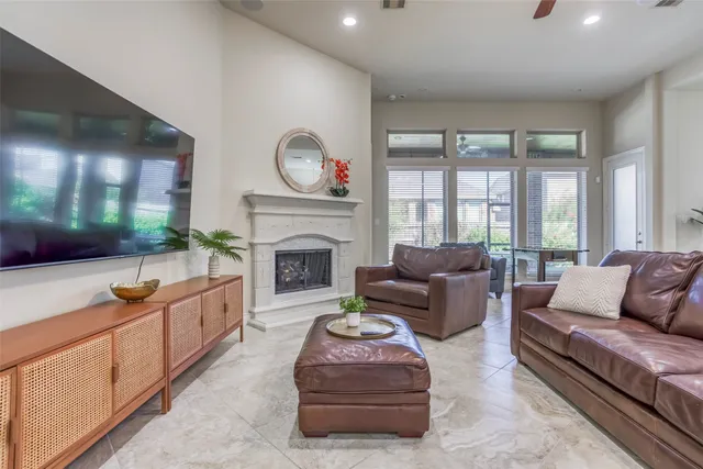 a living room with furniture a fireplace and a floor to ceiling window
