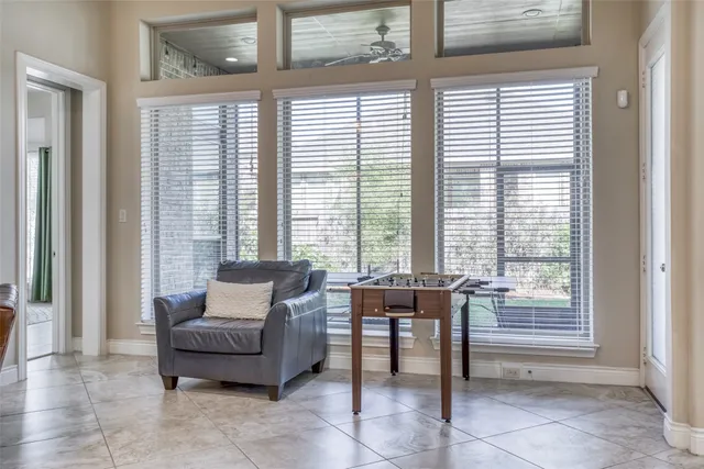a dining room with furniture and large windows