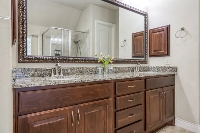 a bathroom with a granite countertop sink and a mirror