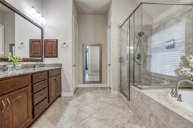 a spacious bathroom with a granite countertop sink mirror and shower