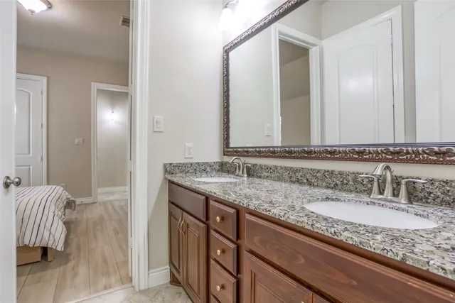 a bathroom with a granite countertop sink and a mirror