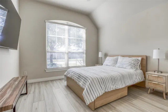 a bedroom with a bed and a large window