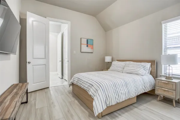 a bedroom with a bed and wooden floor