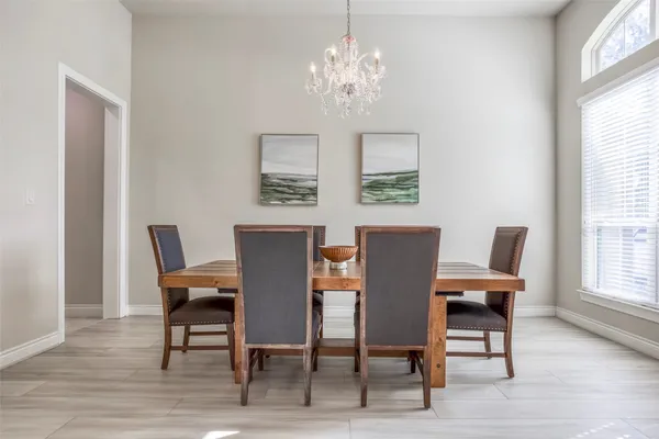 a view of a dining room with furniture a chandelier and wooden floor