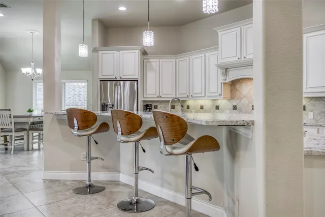 a kitchen with cabinets and chairs