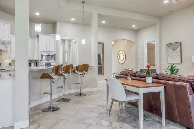 a living room with furniture a chandelier and a view of kitchen