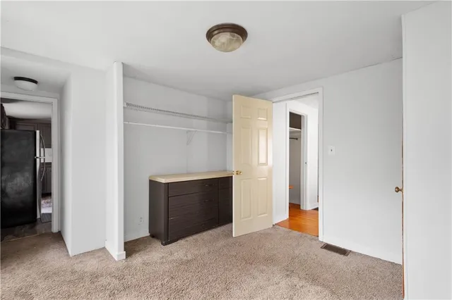 a view of an empty room with closet and a fireplace