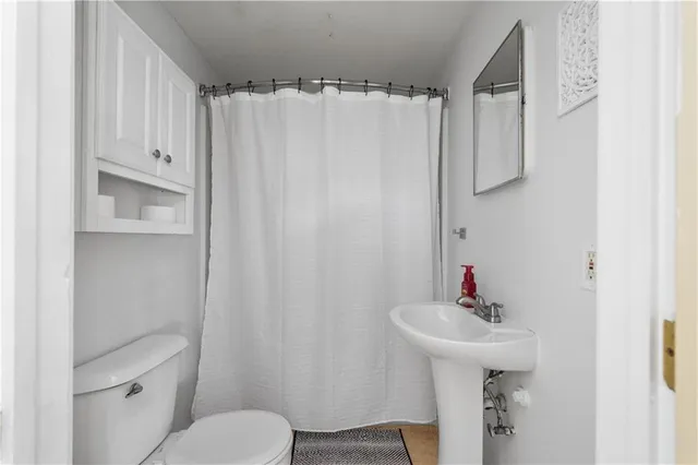 a bathroom with a sink toilet and mirror