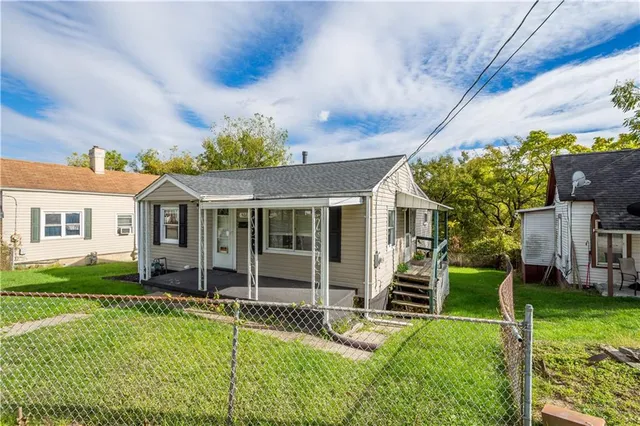 a view of house with a big yard and potted plants