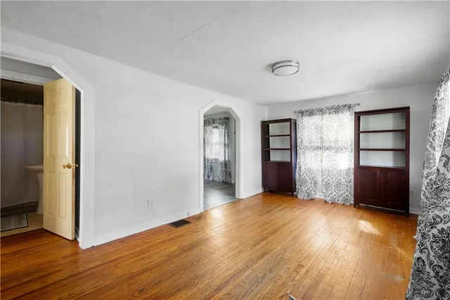 an empty room with closet and windows