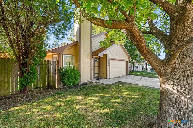 a view of a house with a tree in a yard